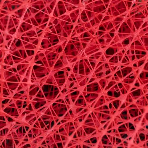 Close-up view of red fibrous plastic mesh with overlapping strands and an open webbed texture