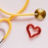 Stethoscope with a plastic protective layer next to a decorative heart