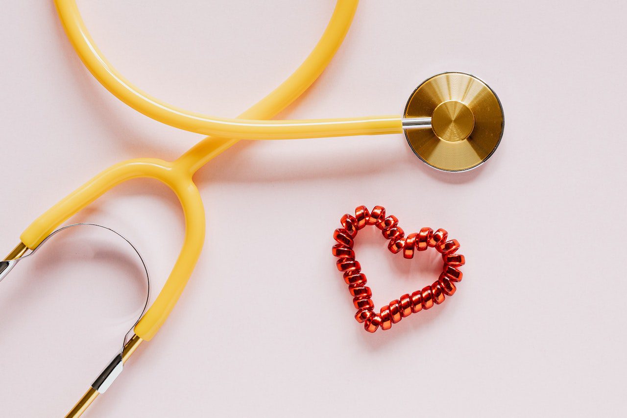 Stethoscope with a plastic protective layer next to a decorative heart